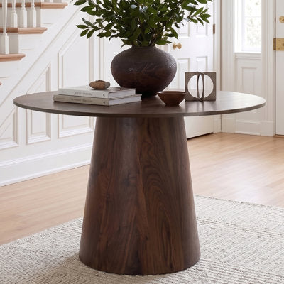 Round pedestal dining table with cone-shaped base and curved edges