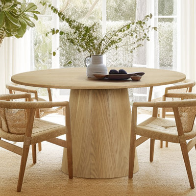 Round solid oak pedestal dining table with natural wood grain finish